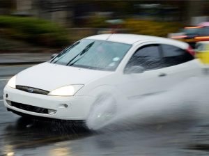 Weißer Ford beim Aquaplaning