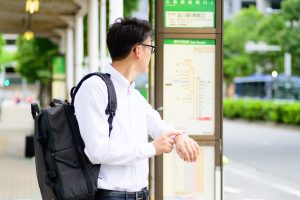 Junger Mann beim Warten auf den Bus