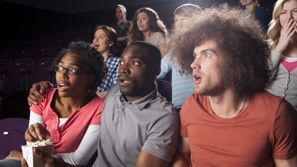 Junge Kinobesucher während einer schockierenden Filmszene